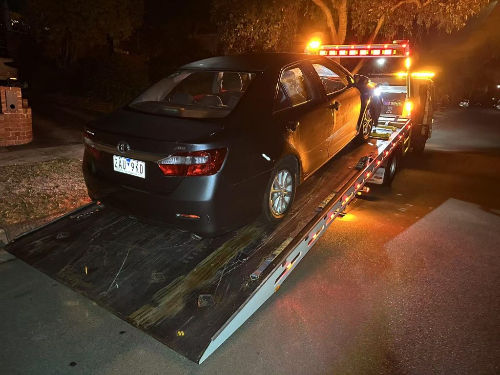 Professional 24 hour tow truck helping stranded driver at night