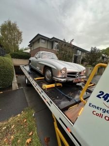 Secure flatbed 24 hour tow truck providing emergency towing to workshop