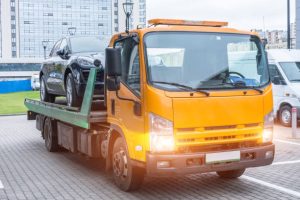 Black car loaded on tow truck Melbourne city roadside assistance