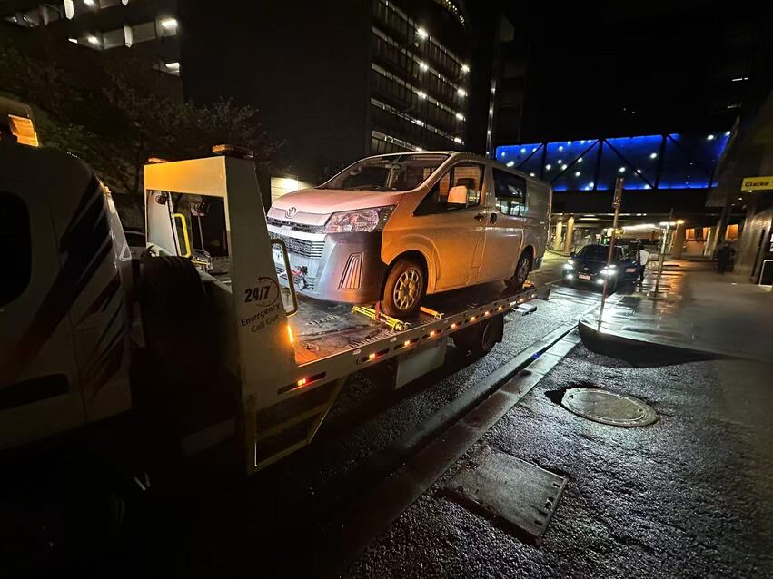 Towing Clayton – white van loaded on tow truck in Melbourne CBD night scene