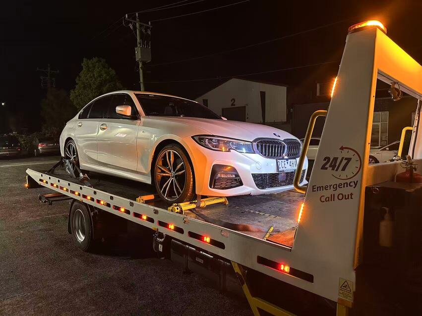 Tow truck Melbourne loading luxury white BMW for car towing melbourne service at night