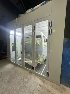 Vehicle undergoing repair work inside a clean spray booth