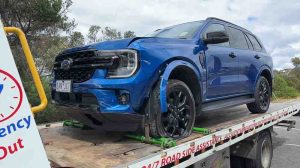 blue SUV being transported by a Maningham Towing flatbed truck as part of an accident towing service in Melbourne