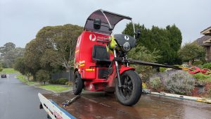 motorcycle tow truck in Melbourne transporting a postal delivery trike on a flatbed tow truck