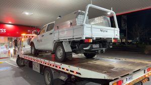 accident towing service by tow truck Melbourne carrying a utility vehicle at night with Maningham Towing