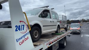 White van secured on a tow truck during wet weather roadside recovery in Melbourne